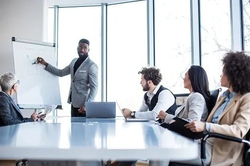 A young manager presenting the graph results on the whiteboard to the board at the conference room.